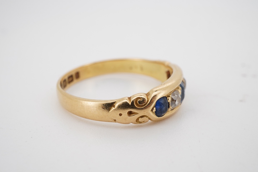 A late Victorian 18ct gold, three stone sapphire and two stone diamond set half hoop ring, size S, gross weight 4.8 grams.
